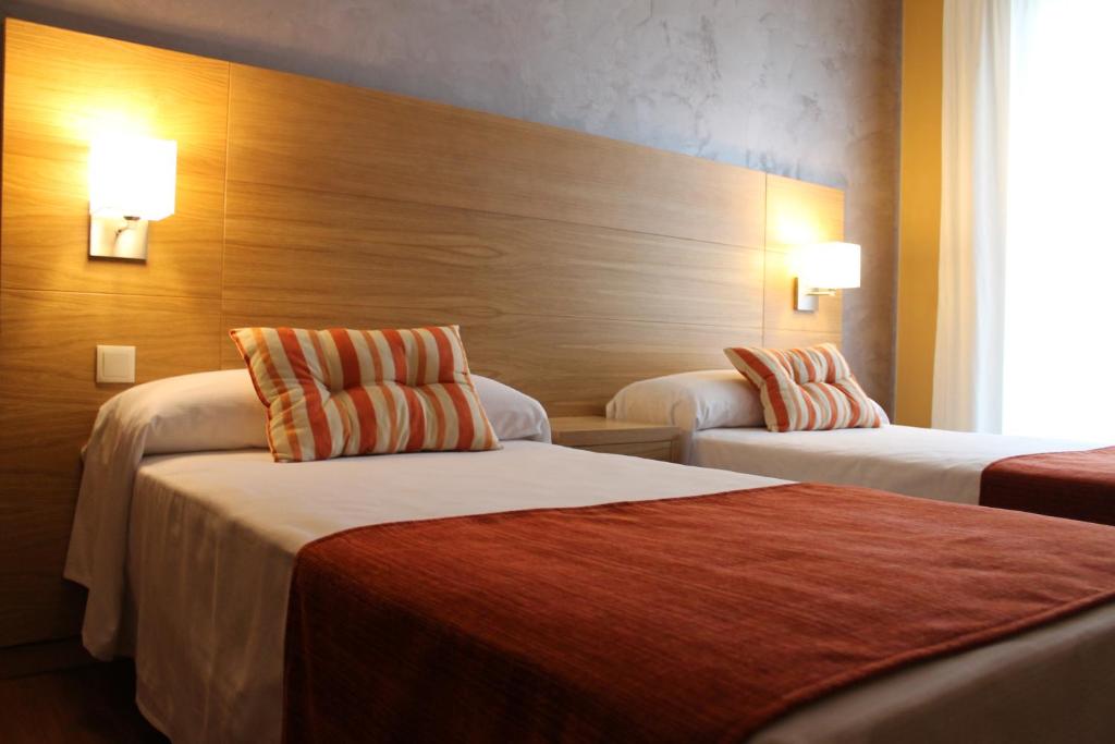 a hotel room with two beds and two lamps at Hotel Carmen in La Cala de Mijas