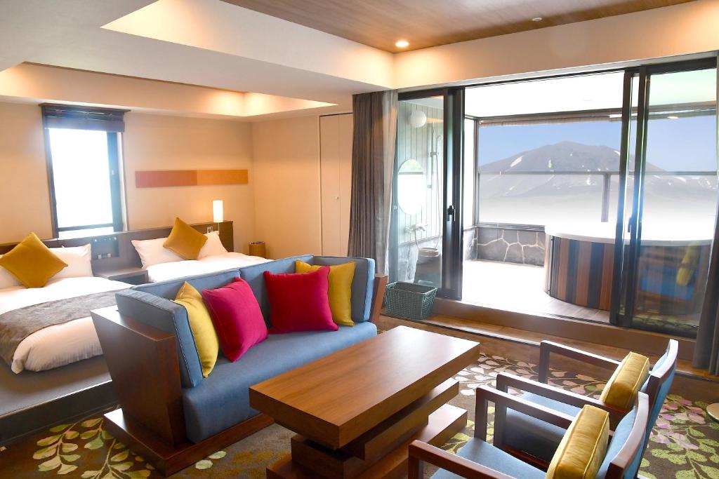 une chambre d'hôtel avec un lit, un canapé et une table dans l'établissement Karuizawakurabu Hotel 1130 Hewitt Resort, à Tsumagoi