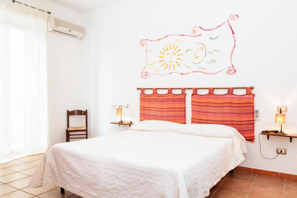 een slaapkamer met een bed met een witte sprei bij La Mezzanella Guesthouse in Porto Torres