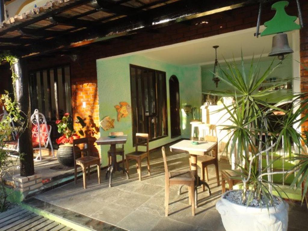 a patio with tables and chairs on a house at Pousada Chez Moi in Cabo Frio