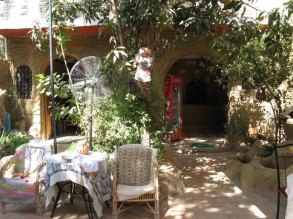 a patio with a table and chairs in a yard at Ramsess Hostel in Luxor
