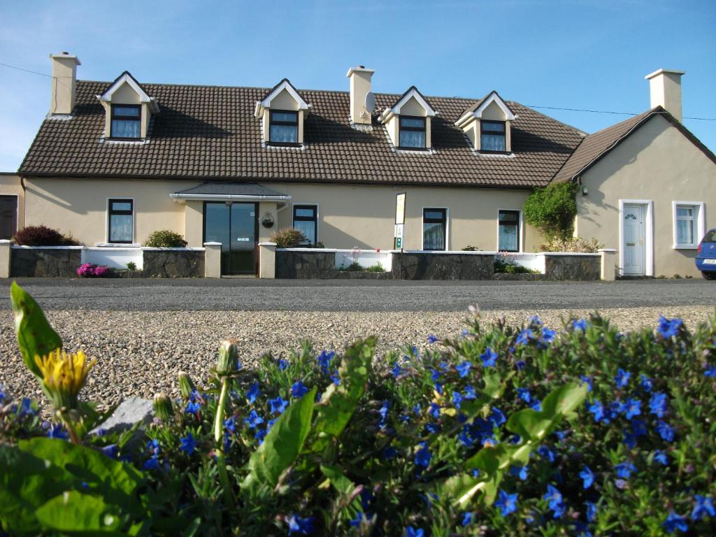 a house with blue flowers in front of it at Riverdale Farmhouse in Doolin
