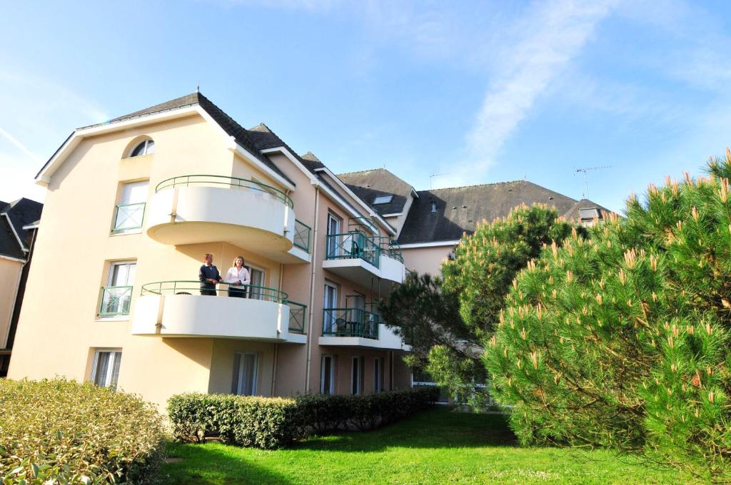 two people standing on a balcony of a building at Azureva Pornichet Baie de La Baule in Pornichet