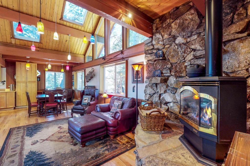 a living room with a large stone fireplace at Peaceful Forest Retreat in Carnelian Bay