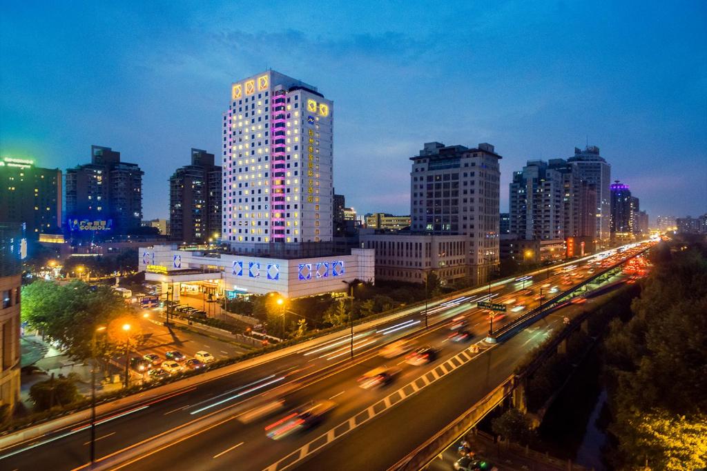 eine Skyline der Stadt bei Nacht mit Verkehr auf einer Autobahn in der Unterkunft Grand Metropark Hotel Hangzhou in Hangzhou