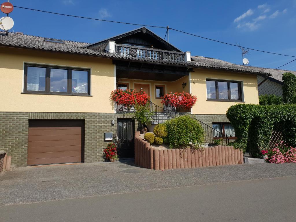 a house with a garage and flowers in front of it at Eifelflair in Retterath