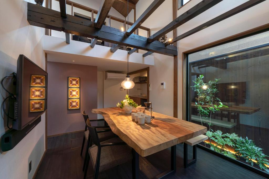 uma sala de jantar com uma mesa de madeira e uma janela em Hinaya Higashiyama Machiya House em Kanazawa