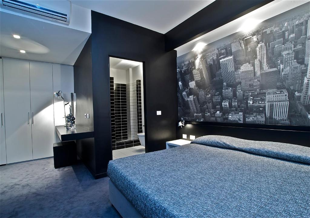 a bedroom with a blue bed and a black wall at Design Suite Tirano in Tirano