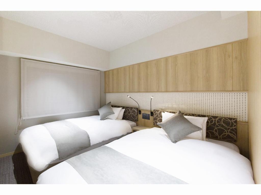 Postel nebo postele na pokoji v ubytování HOTEL HILLARYS Shinsaibashi