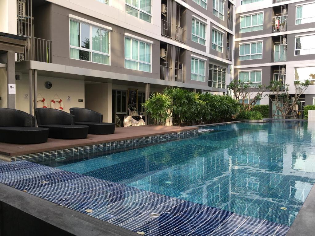 a swimming pool in front of a building at D Condo Nernpra Rayong in Rayong