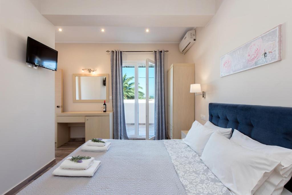 una camera da letto con un letto grande con due asciugamani bianchi di Anita a Perama