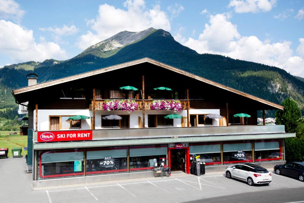 a building with a car parked in a parking lot at Appartementhaus Leitner in Ehrwald