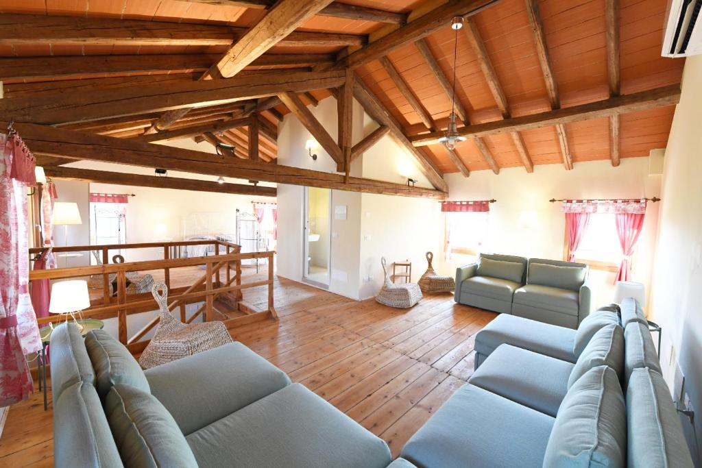 uma sala de estar com sofás azuis e tectos em madeira em Ca dei Ciossi em Concordia Sagittaria