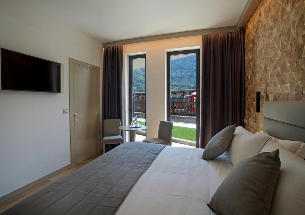 a bedroom with a large bed with a large window at Lifestyle Room Binario Zero in Tirano