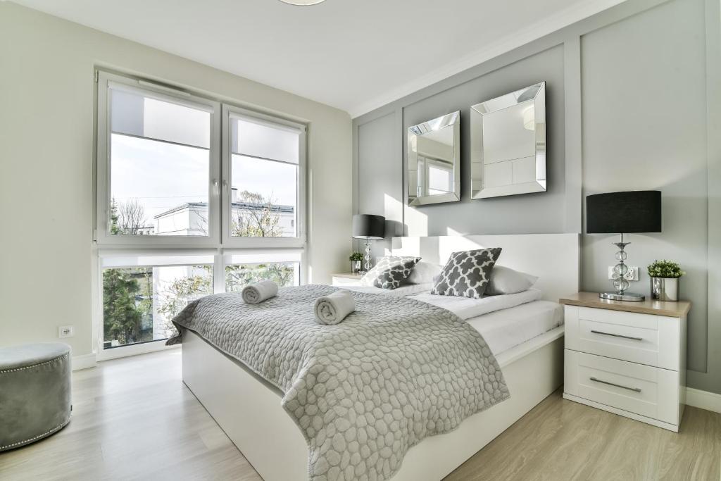 グディニャにあるLTC Apartments Ujejskiegoの白いベッドルーム(ベッド1台、窓2つ付)