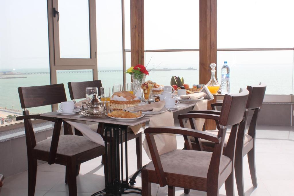 a table with chairs and a table with food on it at Dakhla Sur Mer Hôtel in Dakhla