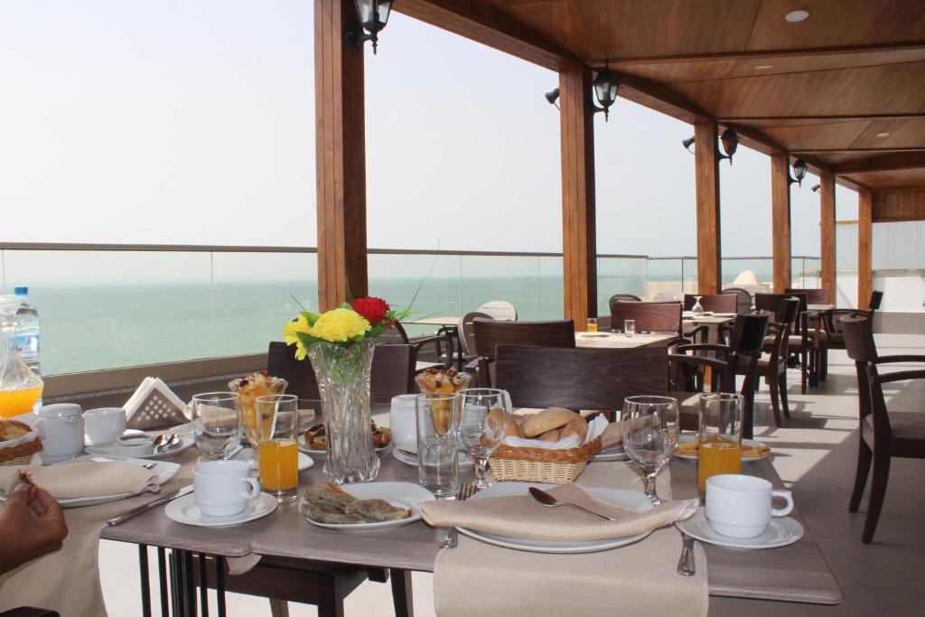 una sala da pranzo con tavoli e sedie e vista sull'oceano di Dakhla Sur Mer Hôtel a Dakhla