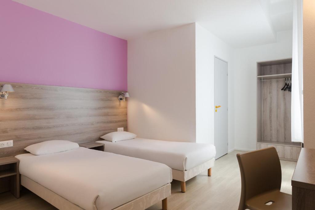 two beds in a room with purple and white walls at The Originals City, Hôtel Nevers Centre Gare (Inter-Hotel) in Nevers