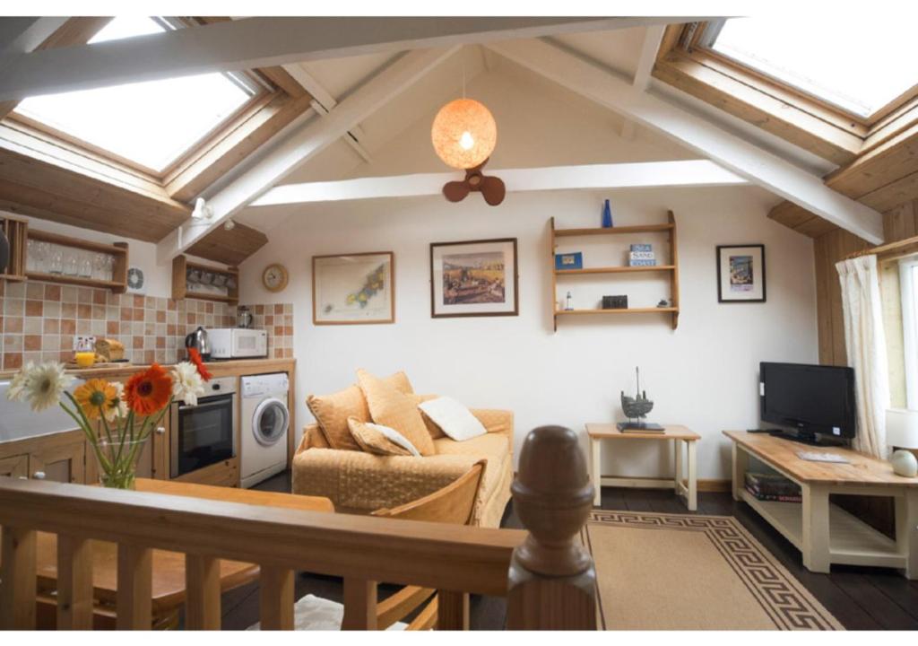 a living room with a ceiling with skylights at Abbey Place Net Loft in Mousehole