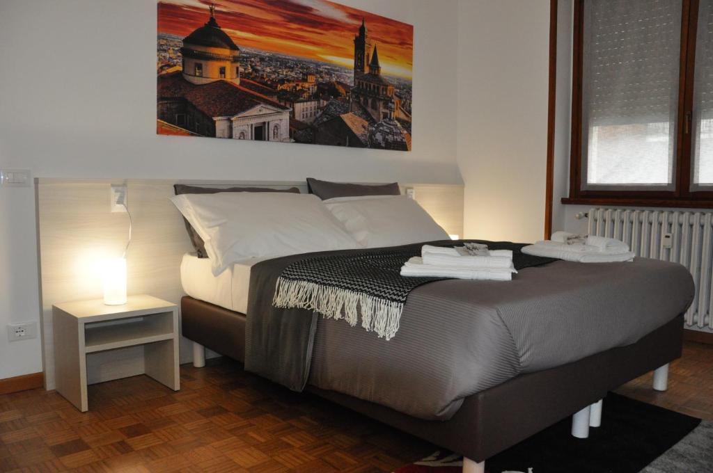 a bedroom with a bed and a painting on the wall at CityWalls Guest House Bergamo in Bergamo