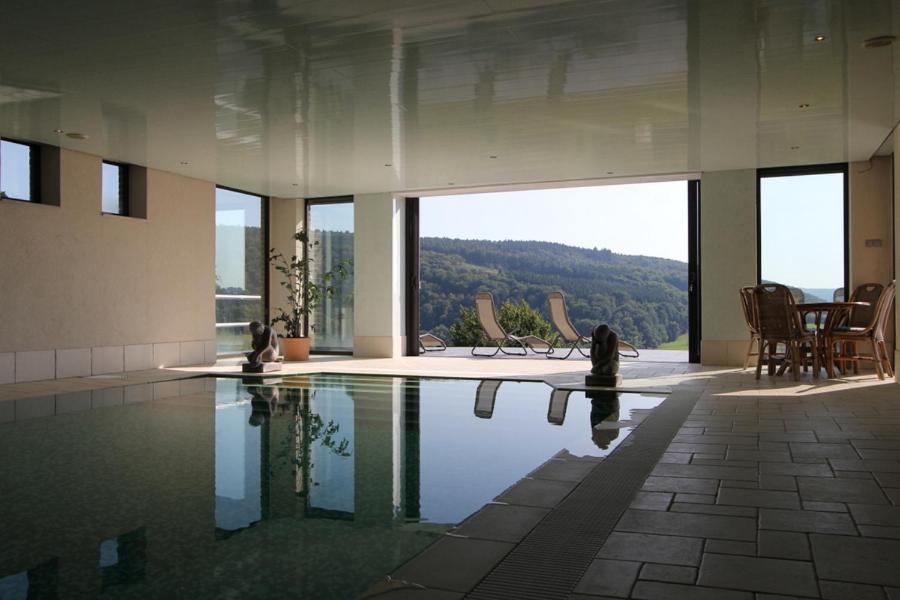 a swimming pool in a building with a view at Sassor Village in Theux