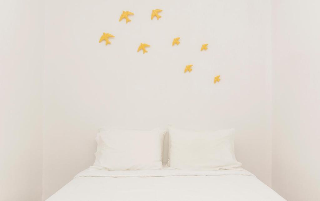 リスボンにあるGood Vibesの白いベッド(壁に蝶が描かれたもの)
