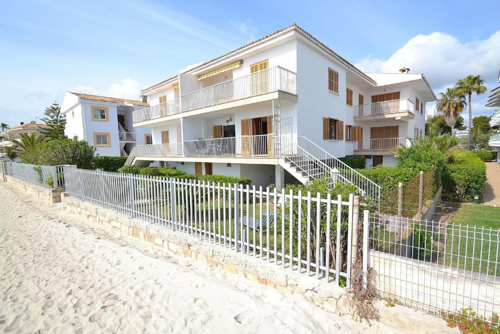アルクーディアにあるApartamento Fantastic 174 by Mallorca Charmeの塀の横の浜辺の白い家