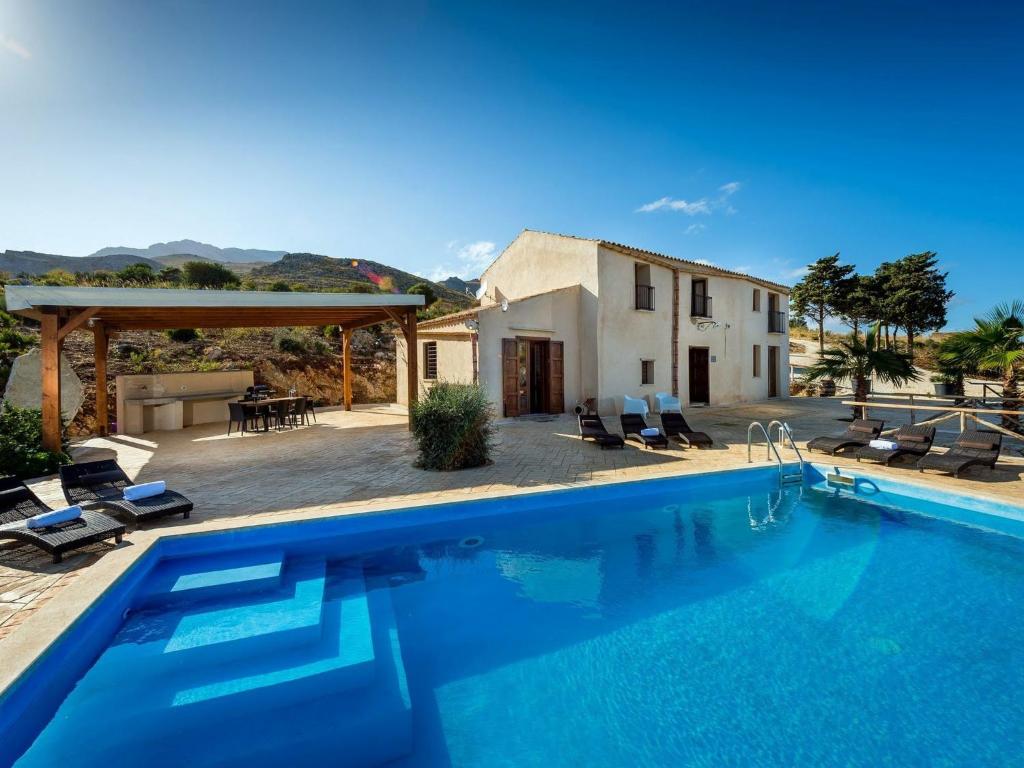une villa avec une piscine en face d'une maison dans l'établissement Belvilla by OYO Villa Le Muse, à Scopello