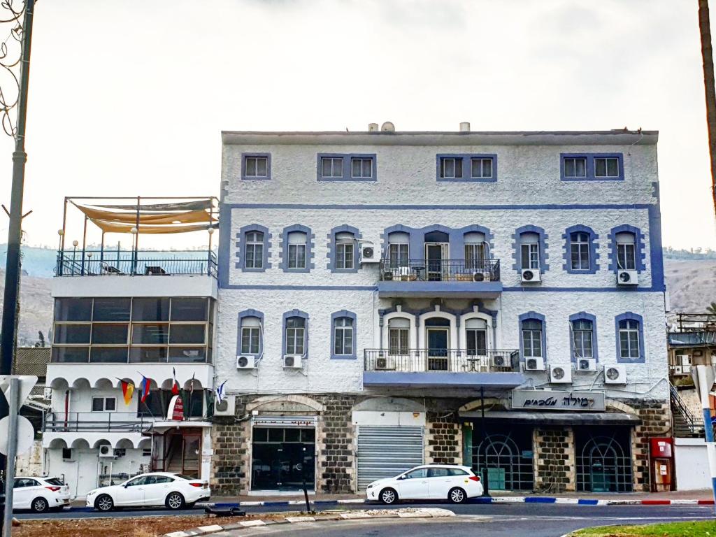 a large building with cars parked in front of it at Atara Hotel in Tiberias