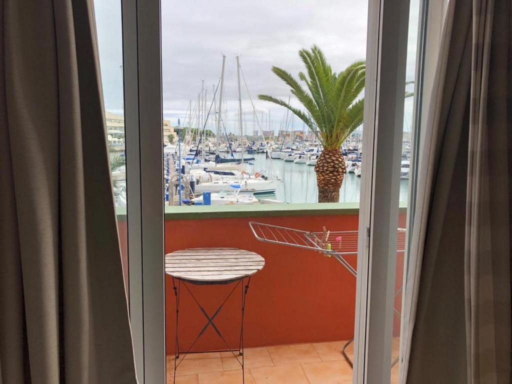 balcón con mesa y vistas al puerto deportivo en Apartamento Playa La Muralla, en El Puerto de Santa María
