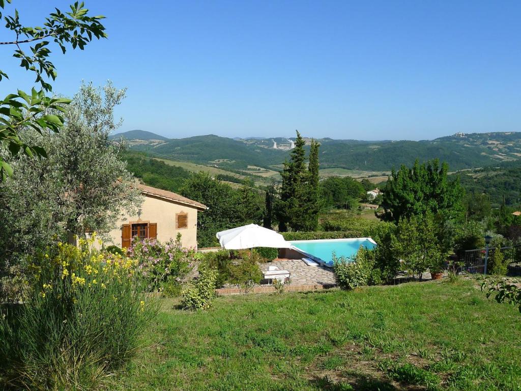 uitzicht op een huis en een zwembad bij Belvilla by OYO Villa Ribattolino in Sasso Pisano