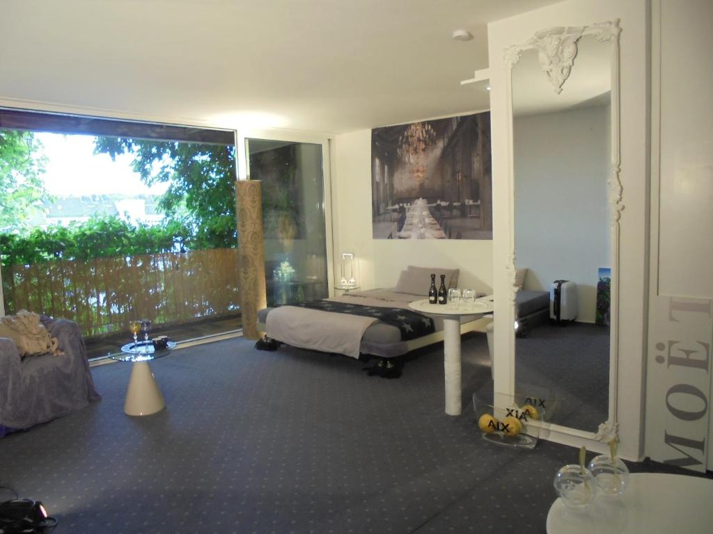 1 dormitorio con cama, mesa y espejo en Pallazzo Alfonso, en Aachen
