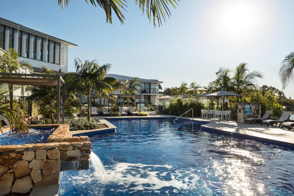 a large swimming pool in a tropical setting at Sails Port Macquarie by Rydges in Port Macquarie