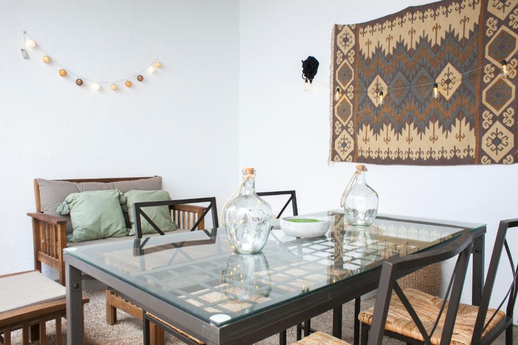 comedor con mesa de cristal y sofá en AlohaMundi Bailén, en Sevilla