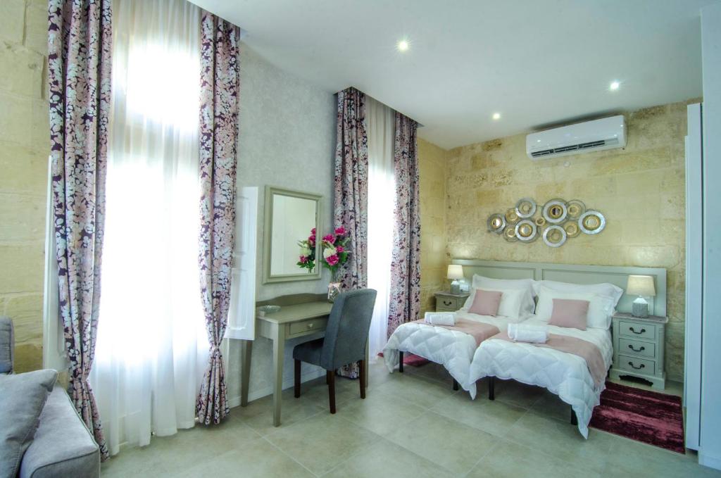 a bedroom with two beds and a desk and a mirror at Santa Lucia B & B Suite in Rabat