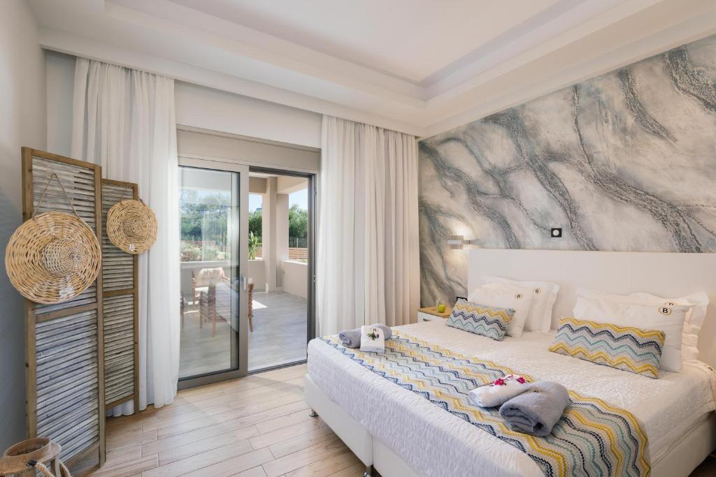 a bedroom with a bed with a painting on the wall at Belvedere Luxury Apartments & Spa in Plakias