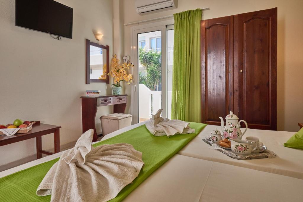 a bedroom with a bed with a green and white blanket at Corali Studios in Plakias