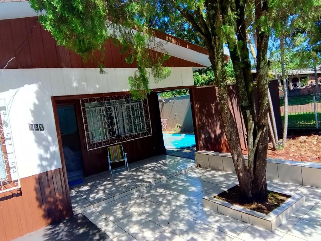 una casa con un árbol delante de ella en Casa do Sussego en Foz do Iguaçu