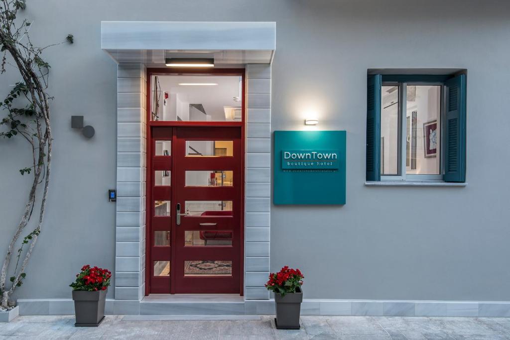 a red door with a sign on the side of a building at DownTown Hotel in Nafplio