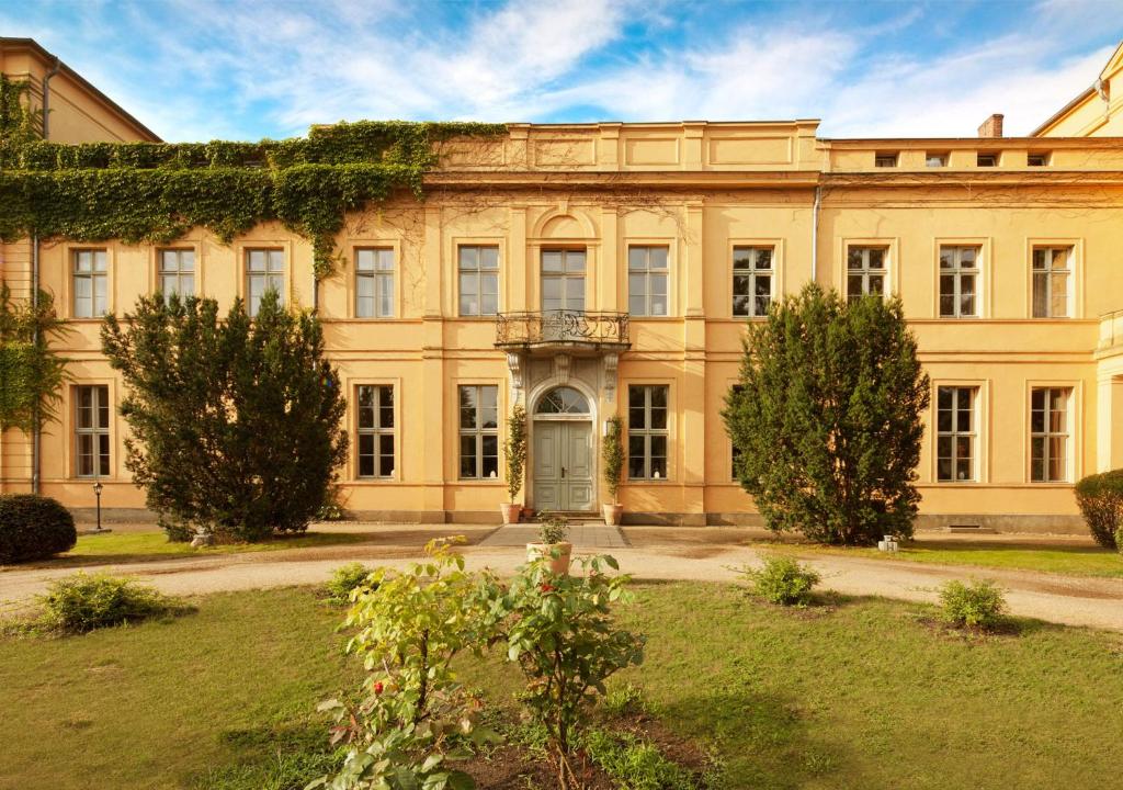 un viejo edificio con hiedra creciendo en él en Schlosshotel Ziethen, en Kremmen