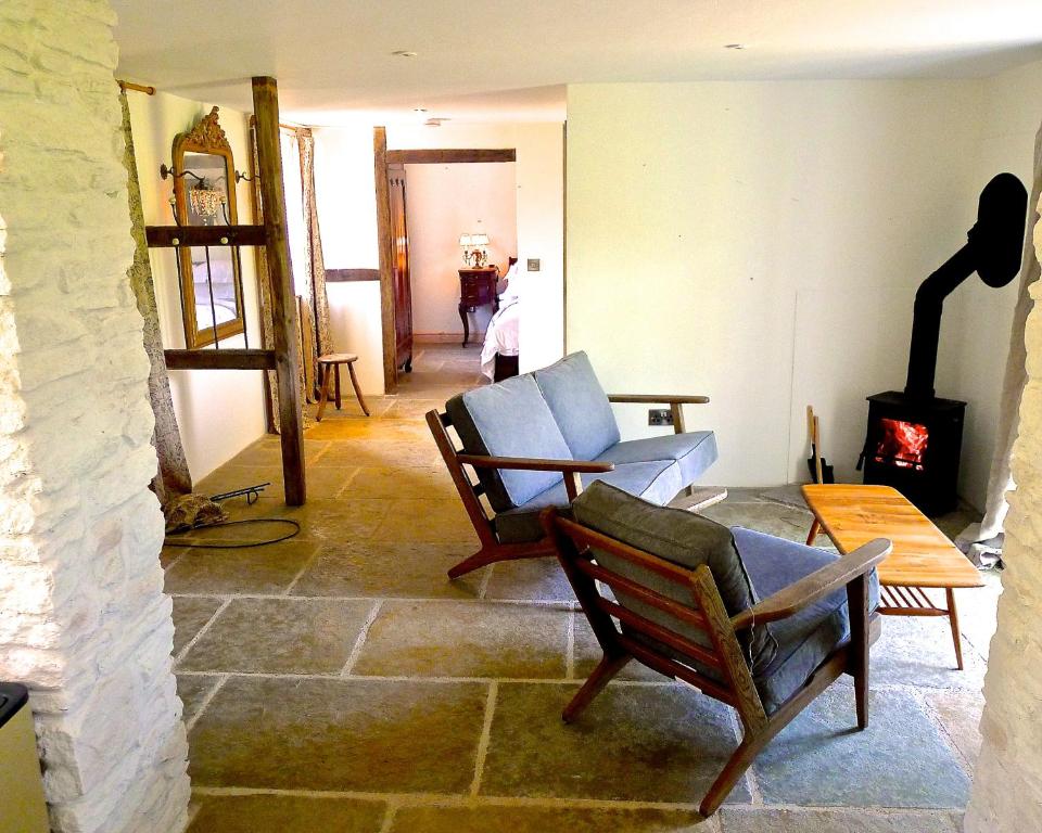 a living room with two chairs and a fireplace at Glanwye in Hay-on-Wye