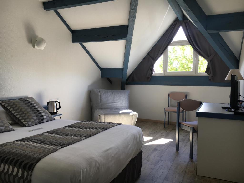 a bedroom with a bed and a desk and a window at Hôtel Pédagogique Coeur d'Apcher in Saint-Chély-dʼApcher