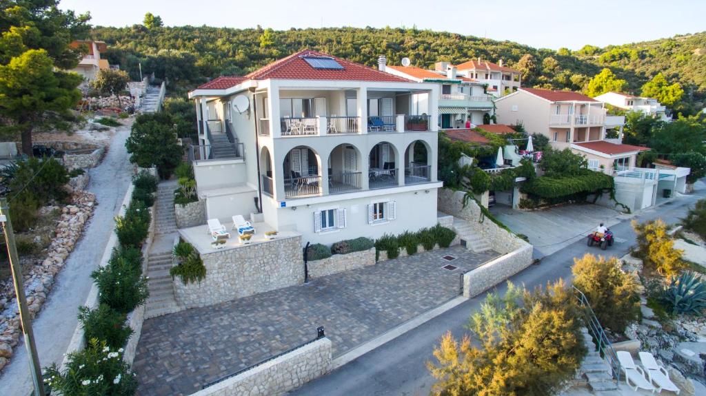 a large white house on a street at Apartments Lavanda in Vinišće