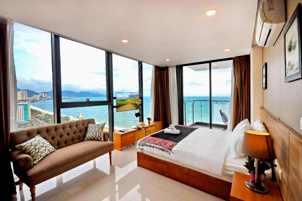 - une chambre avec un grand lit et de grandes fenêtres dans l'établissement Holi Beach Hotel & Apartments, à Nha Trang