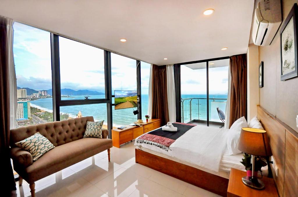 a bedroom with a large bed and large windows at Holi Beach Hotel & Apartments in Nha Trang