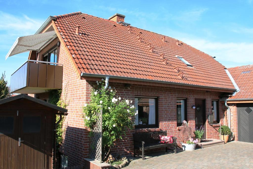 ein Backsteinhaus mit rotem Dach in der Unterkunft Ferienwohnung Hohenholte in Havixbeck