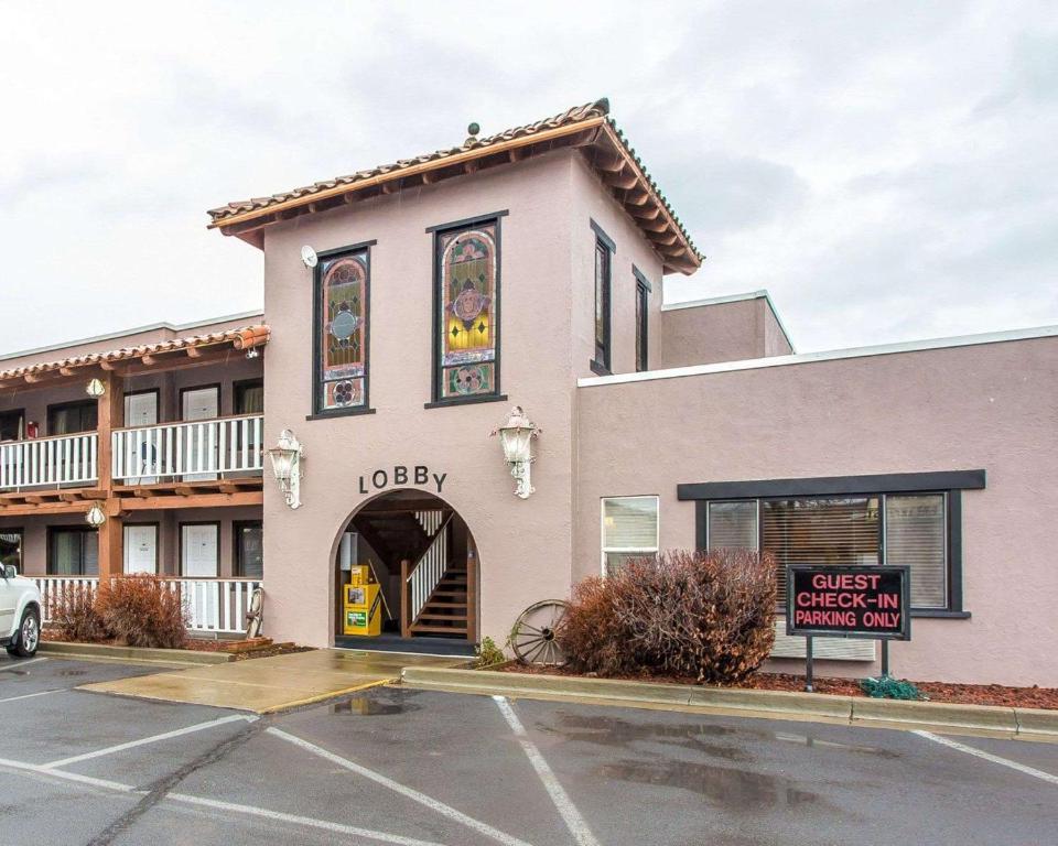 een gebouw met een bord op een parkeerplaats bij Rodeway Inn Baker City in Baker City