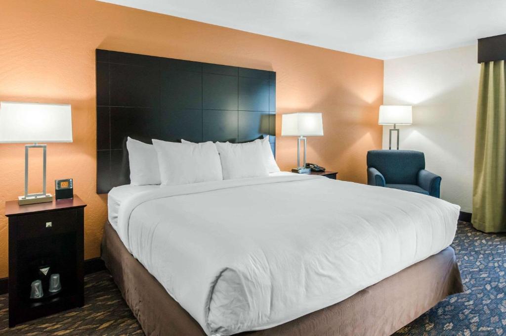 um quarto de hotel com uma cama grande e uma cadeira em Comfort Inn & Suites em Ashland