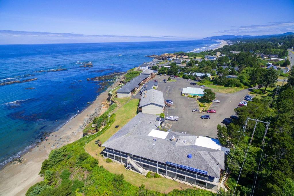 - une vue aérienne sur un bâtiment à côté de l'océan dans l'établissement Clarion Inn Surfrider Resort, à Depoe Bay