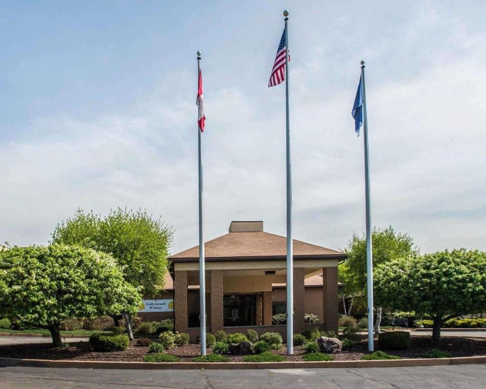 trois drapeaux sur des bâtons devant un bâtiment dans l'établissement Comfort Inn Pocono Lakes Region, à Lake Ariel